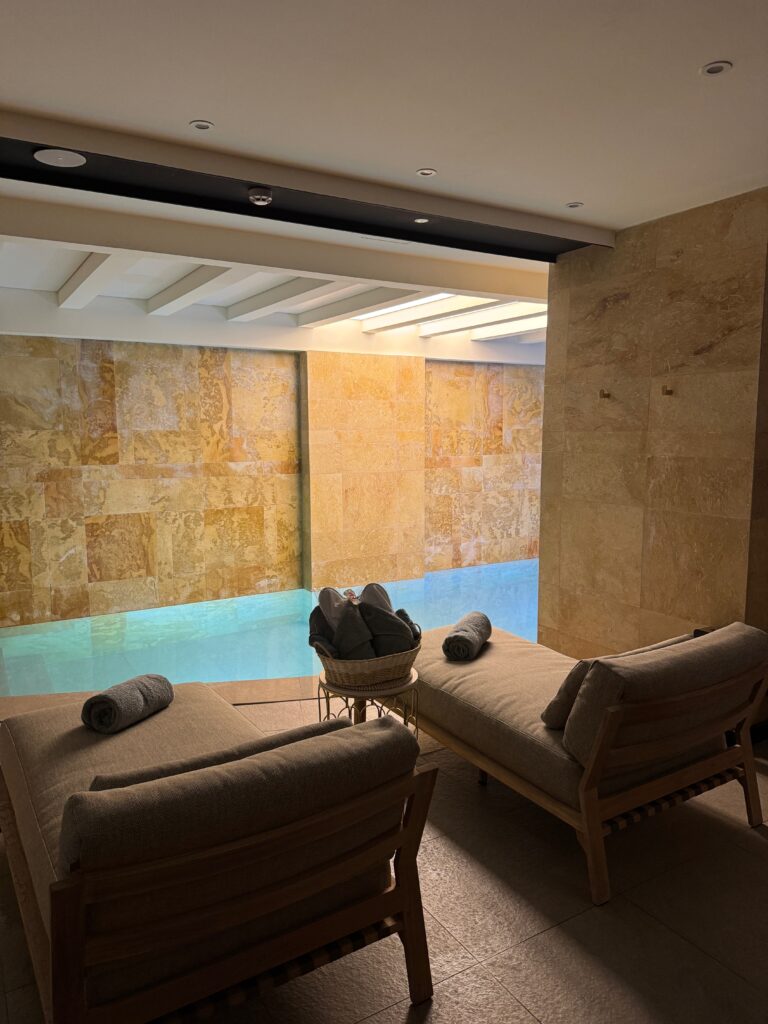 Indoor spa pool with loungers and stone walls